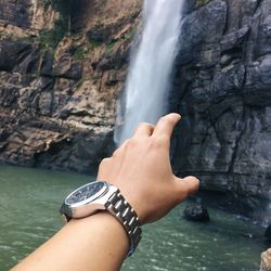 Midsection of woman looking at waterfall