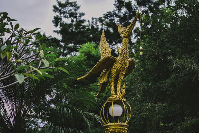 Low angle view of statue against trees