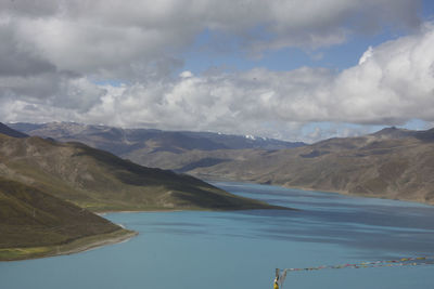 Scenic view of lake by mountains against sky