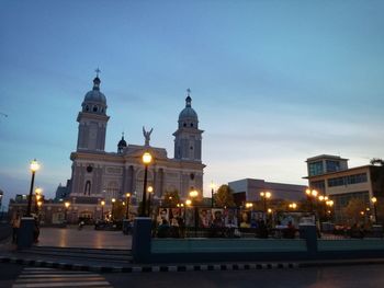 Illuminated buildings in city at dusk