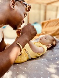 High angle view of shirtless baby boy lying on bed at home