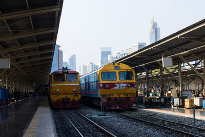 Train on railroad station platform in city against sky