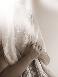 Woman covering face with white fabric