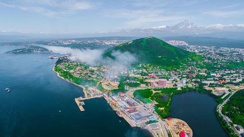 High angle view of cityscape by sea against sky