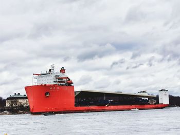 Red ship on sea against sky during winter