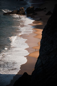 Rock formation on beach against sky during sunset