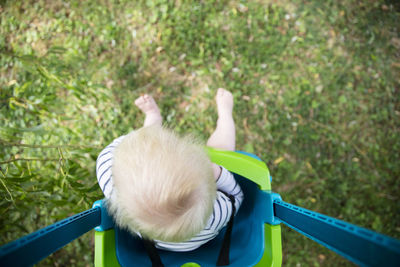 High angle view of boy sitting in swing