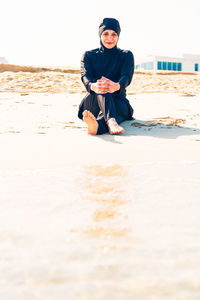 Portrait of a smiling young woman standing on beach