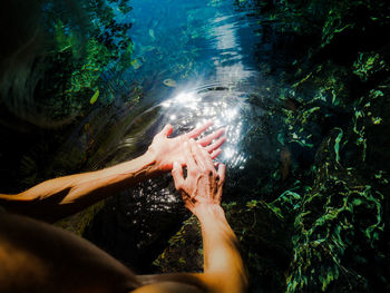 Cropped image of woman washing hands in lake