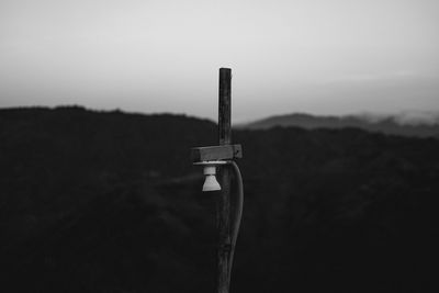 Close-up of wooden post on field against sky
