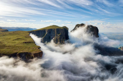 Scenic view of waterfall against cloudy sky