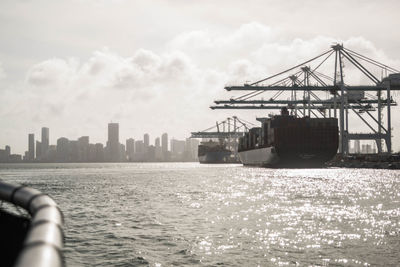 View of cityscape by sea against sky