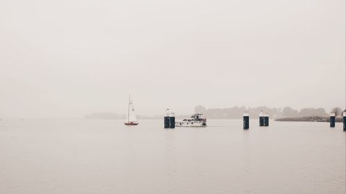 Sailboats in sea against clear sky