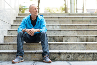 Full length of man sitting on staircase