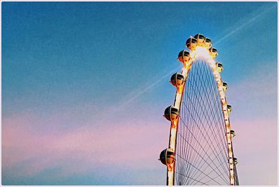 Low angle view of ferris wheel against blue sky