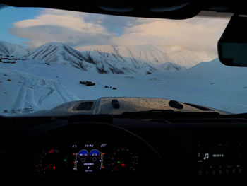 Aerial view of mountain seen through car windshield during winter