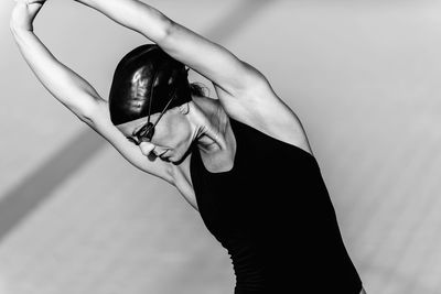 Woman in swimwear stretching hands