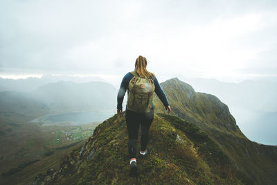 Rear view of woman looking at mountain against sky