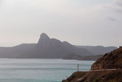 Scenic view of sea and mountains against sky