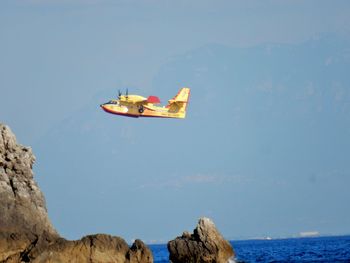 Low angle view of rocks in sea against sky