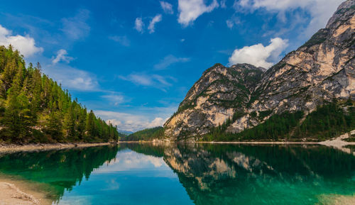 Scenic view of lake by mountains against sky