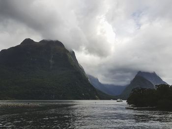 Scenic view of lake by mountains against sky