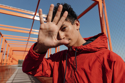 Portrait of young man standing against sky