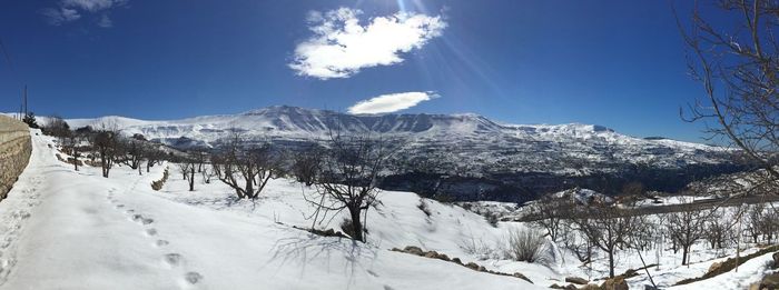 Panoramic view of snow covered landscape against sky