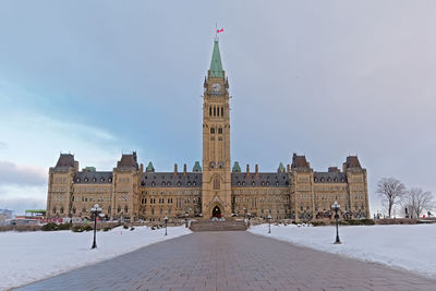 Buildings in city against sky during winter