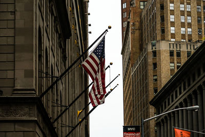 Low angle view of flag against buildings in city