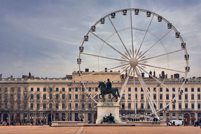 Bellecour square with louis xiv statue and a big ferris wheel