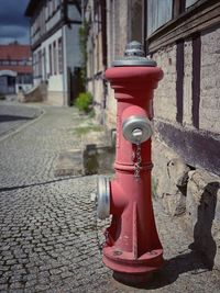 Red fire hydrant on street by building