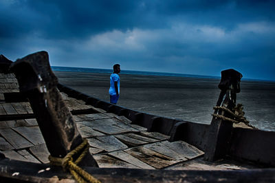 Man standing on pier over sea against sky