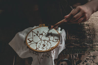 Cropped hand of person embroidering textile