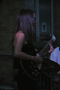 Woman playing guitar at home