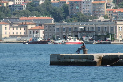 Boat in sea against cityscape