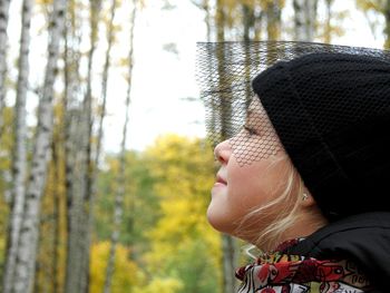 Side view of boy against trees