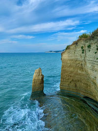 View of rock formation in sea against sky