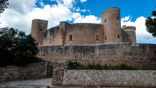 Low angle view of historic building against cloudy sky