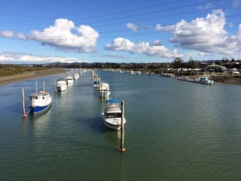 Boats moored at dock against sky