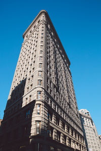 Low angle view of office building against blue sky