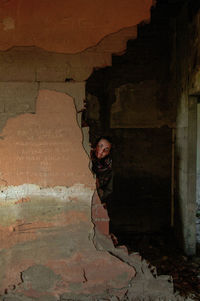 Portrait of smiling boy standing against brick wall