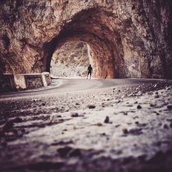 Rear view of man walking in tunnel