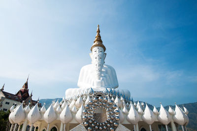 Low angle view of buddha statues at wat pha son kaew against sky