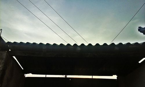 Low angle view of silhouette roof against sky