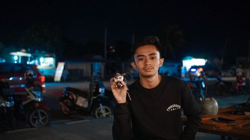 Portrait of man standing in city at night