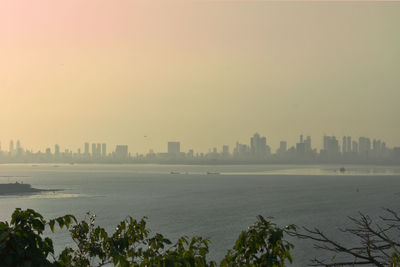 Scenic view of sea and buildings against clear sky