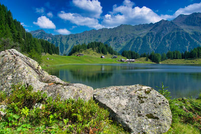 Scenic view of lake by mountains against sky