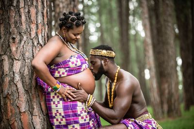 Midsection of woman with arms raised in forest