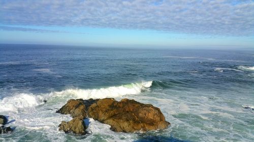 Scenic view of sea and sandstone rocks against sky